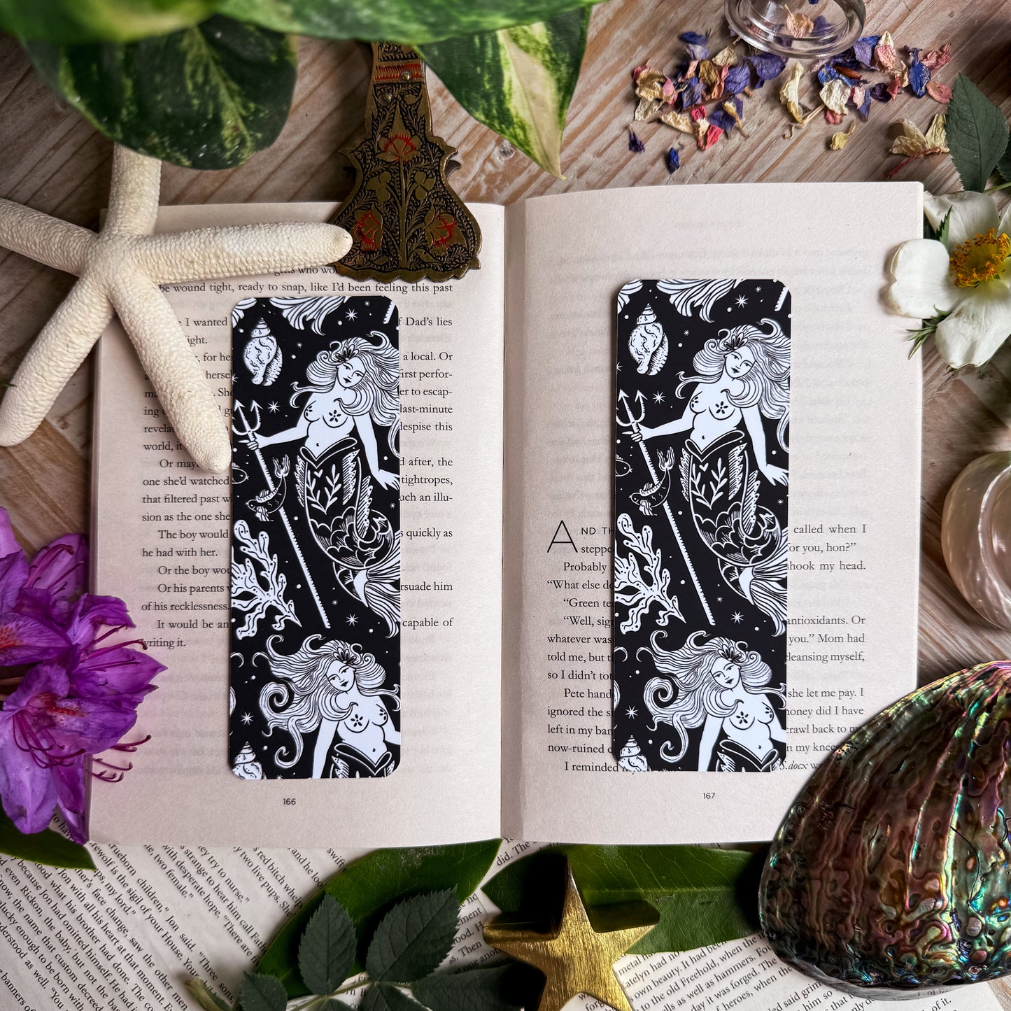 Two mermaid bookmarks, side by side on an open book.