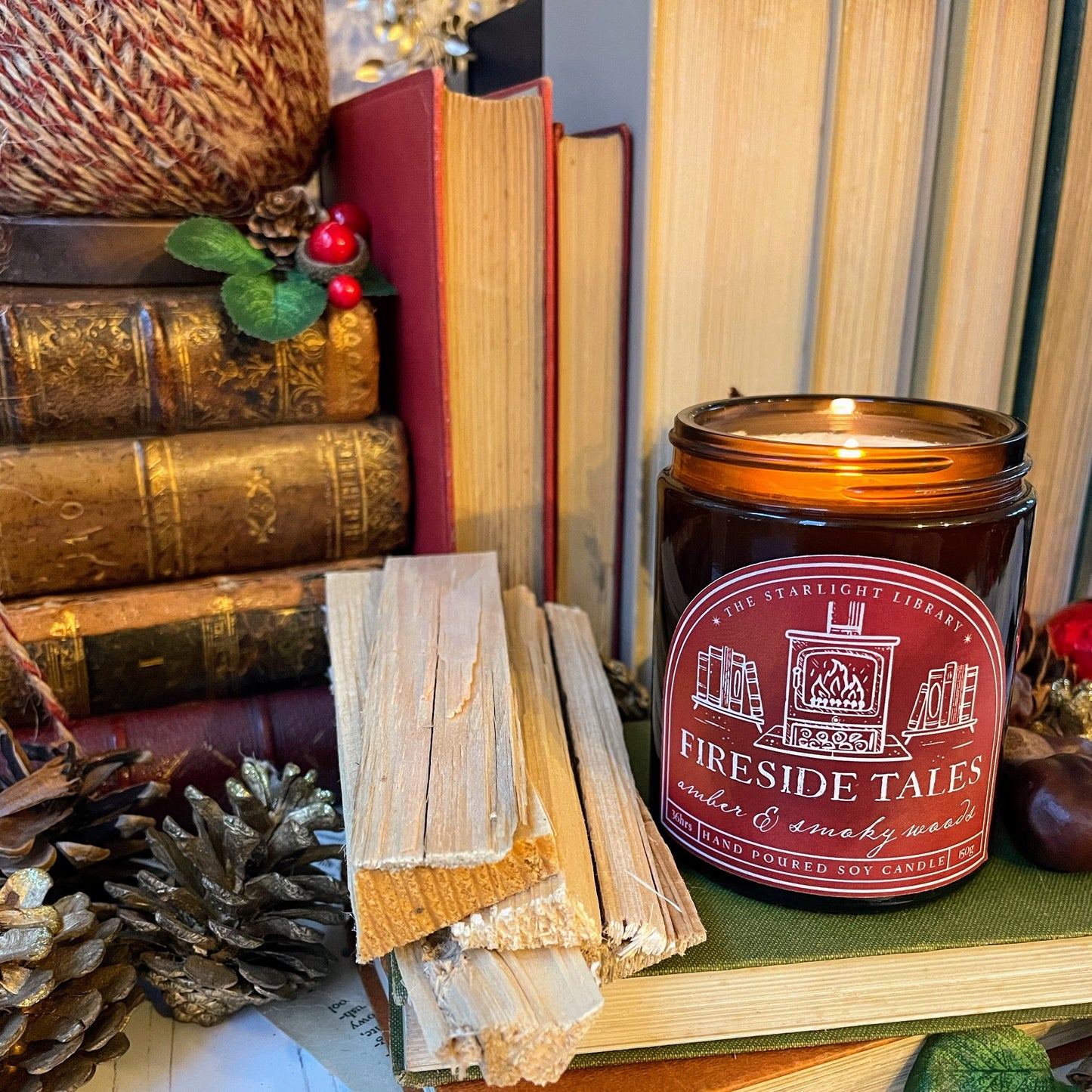Fireside Tales candle on a stack of books with decorative elements