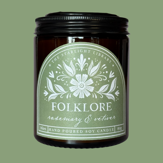 A Folklore candle against a matching green studio background