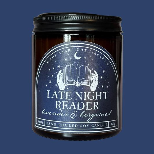 A Late Night Reader candle against a matching blue studio background