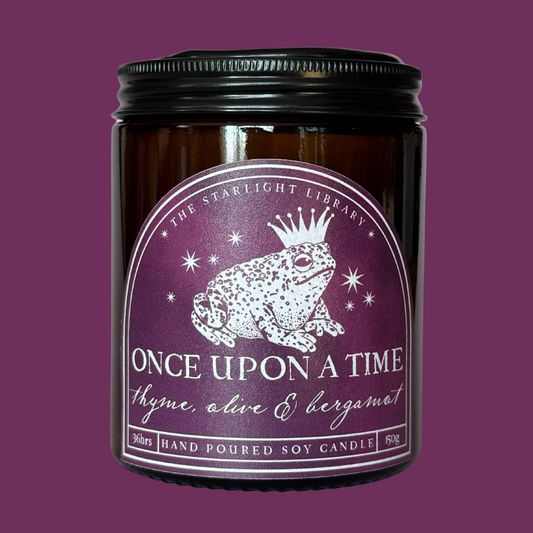 A Once Upon A Time candle against a matching purple studio background.