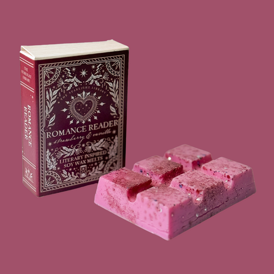 A Romance Reader wax melt bar, with it's book box,in front of a pink studio background.