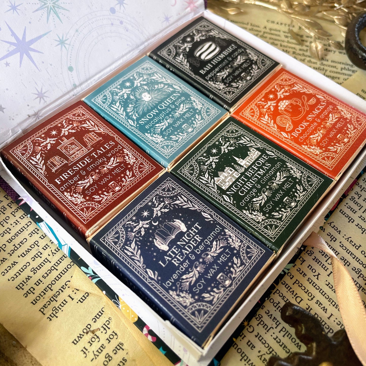 Six mini book wax melts. They are laid in an open box box.