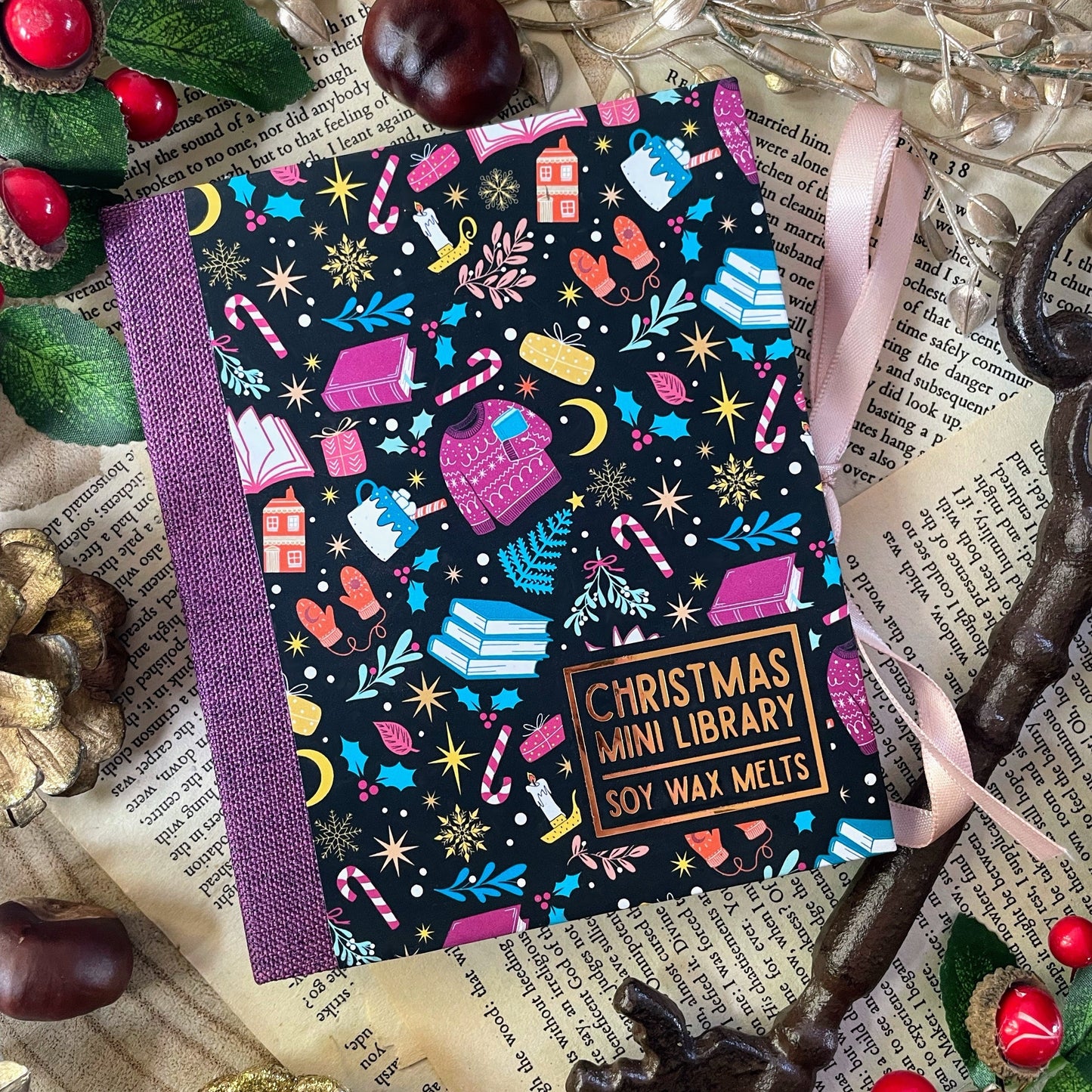 Christmas-themed mini library of wax melts with decorative elements on a textured surface.