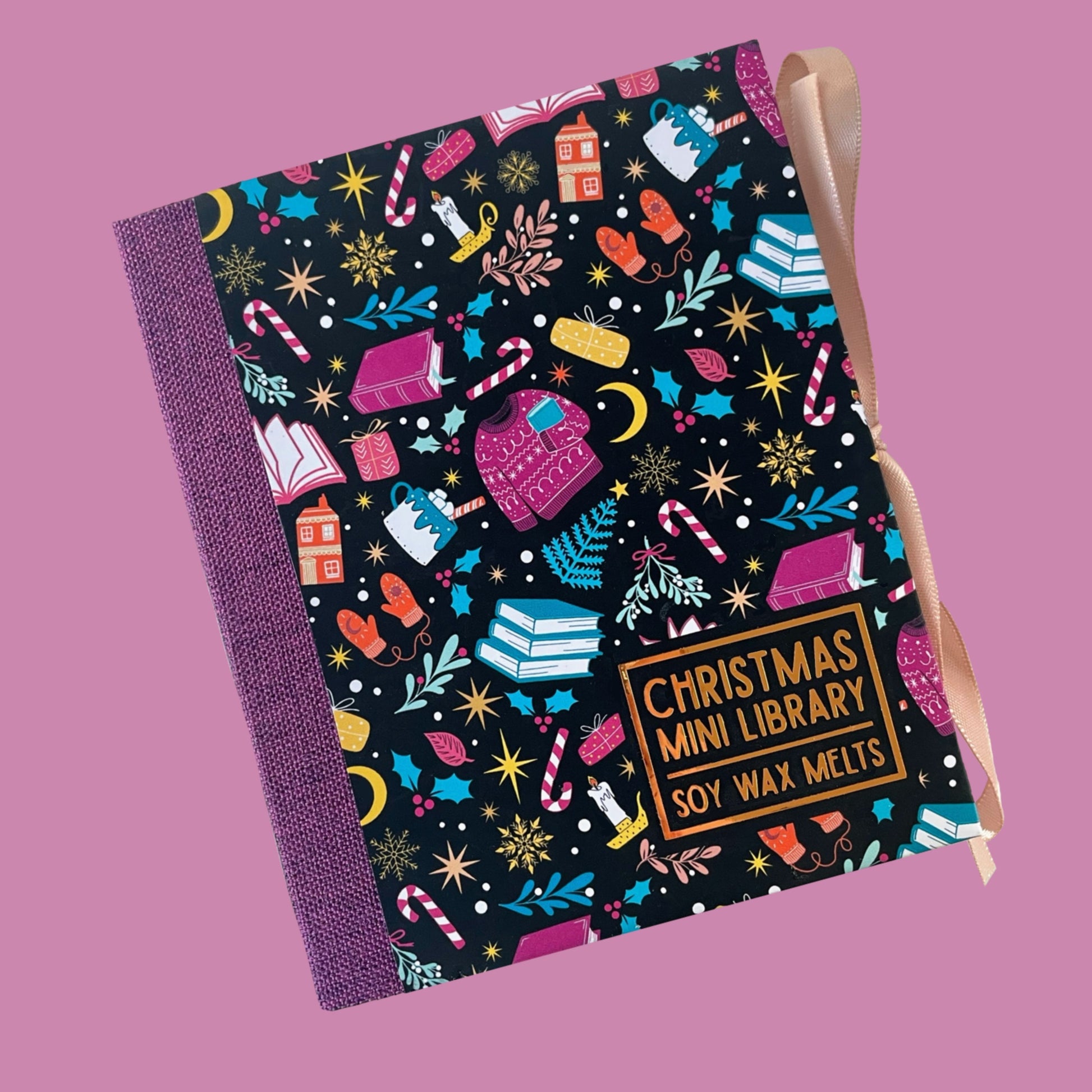 Christmas-themed wax melt package with colorful design on a pink background