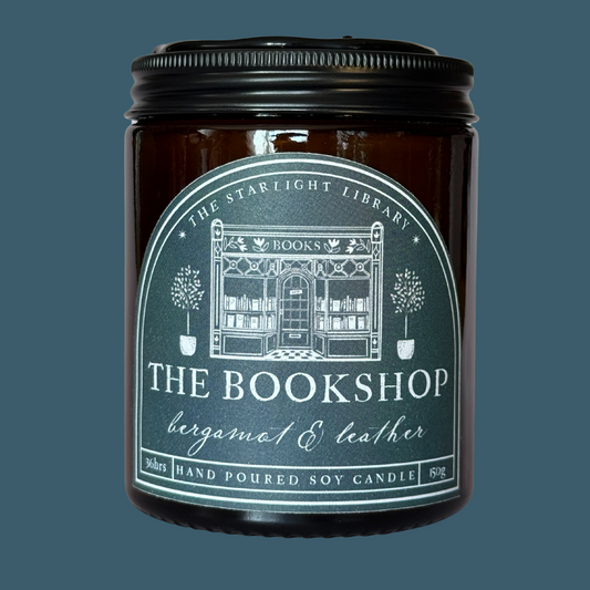 The Bookshop candle against a matching teal studio background.