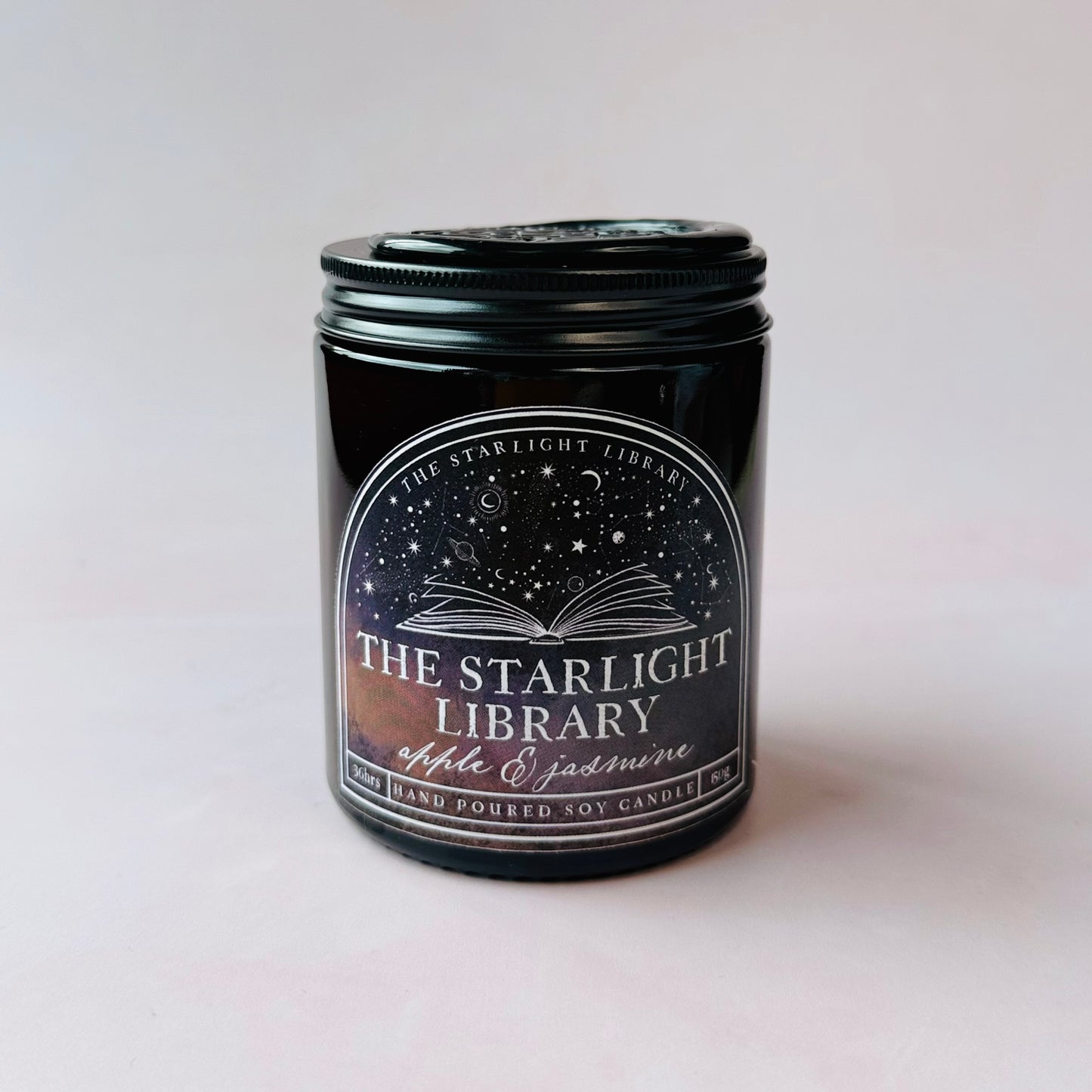 The Starlight Library candle against a plain studio background.